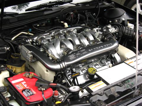 2003 Ford Taurus - Detailed engine bay shot of a Ford SHO V6 with its polished Yamaha-cast intake manifold reading "SHO 24 VALVE DOHC" and curved runners over…