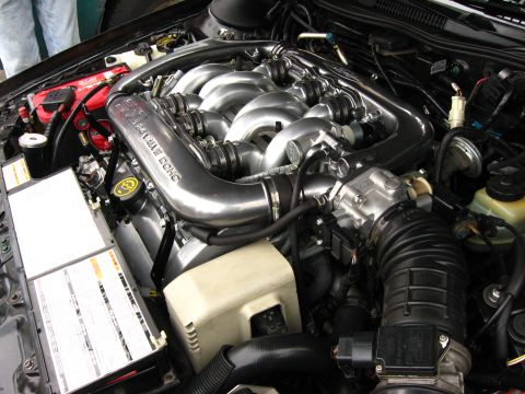 2003 Ford Taurus - Engine bay view of a transverse V6 with a polished aluminum intake manifold cast "24 VALVE DOHC," showing the throttle body, corrugated int…