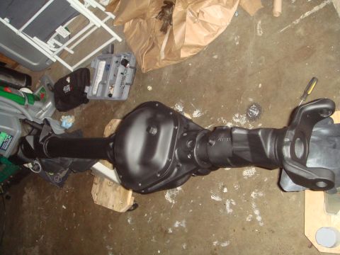 1992 Ford Bronco - A black-painted Ford 9-inch rear axle assembly is shown resting on wooden blocks on a concrete floor. The assembly includes the differentia…
