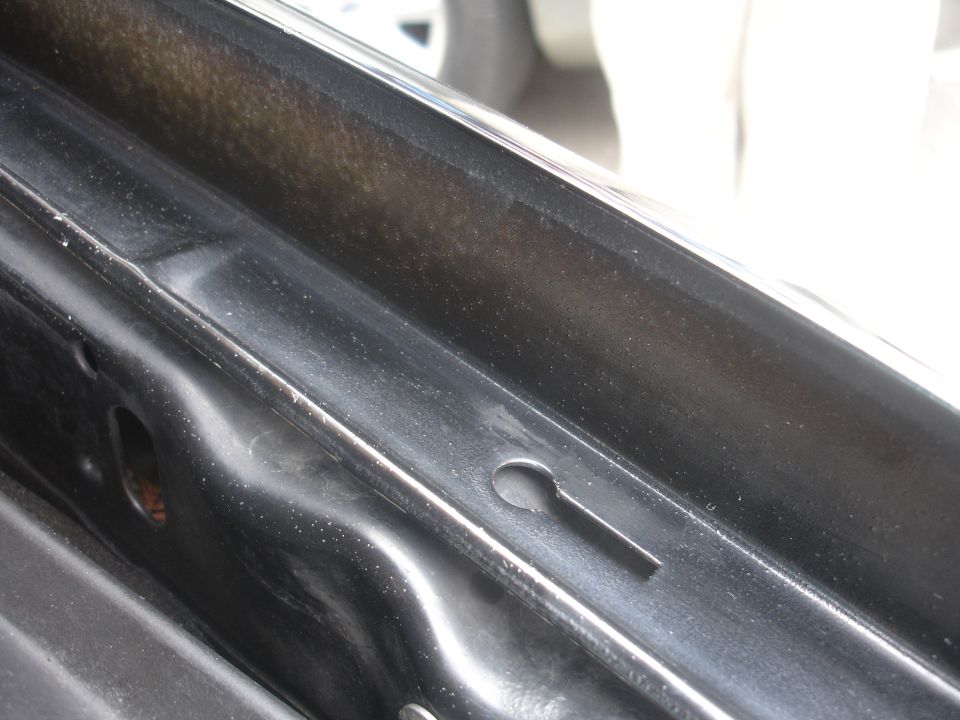 Close-up of black painted interior door jamb with a keyhole-shaped opening.