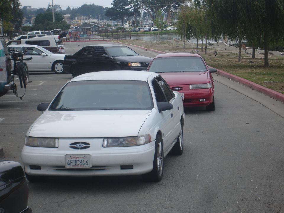 White 1990 Ford Taurus with license plate 4EDC846 parked in a lot.