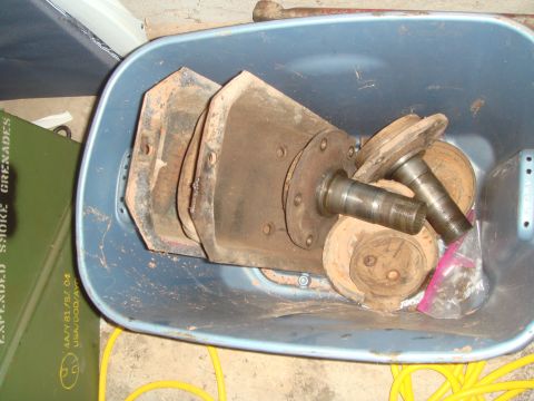 1992 Ford Bronco - A blue plastic bin is filled with various rusty metal parts, including what appear to be brake rotors, hubs, and possibly parts of a suspen…