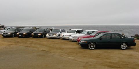 2003 Ford Taurus - A row of eight Ford Taurus and Mercury Sable sedans of several generations parked in an arc on a dirt bluff overlooking the ocean under gra…
