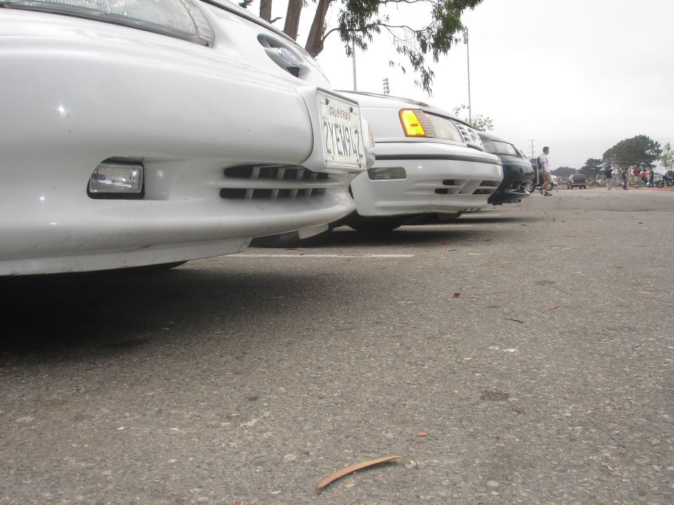 Close-up of the front bumper and grille of a white sedan.