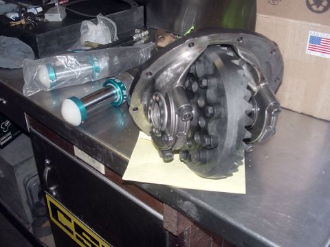 1979 Ford Bronco - Differential housing and King shock absorber parts are on a metal workbench.