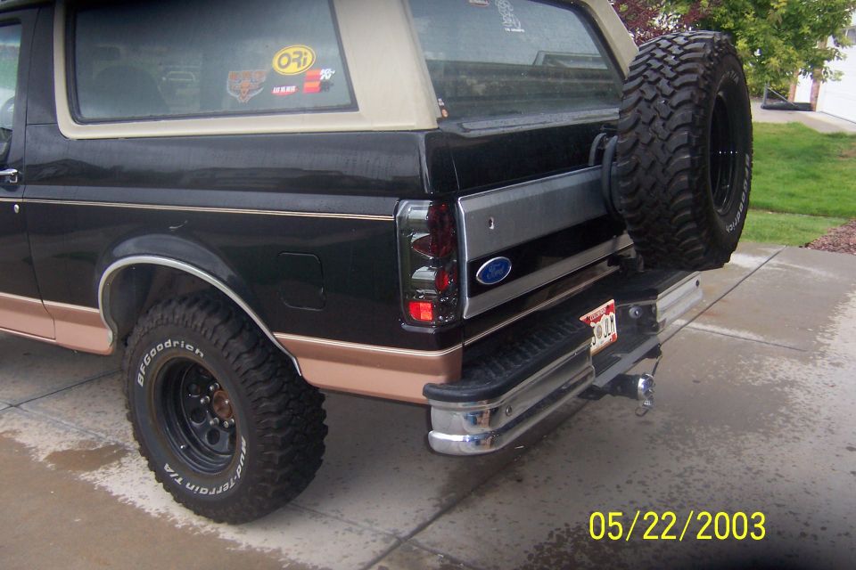Rear of black and tan Ford Bronco with tailgate-mounted spare tire