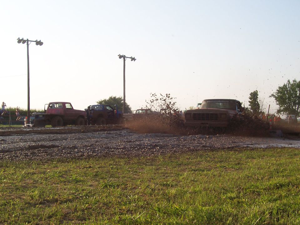 Pickup truck driving through mud pit