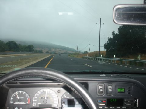 1990 Ford Taurus - Driving on a foggy highway from the interior of a 1990 Ford Taurus, showing the dashboard and steering wheel.