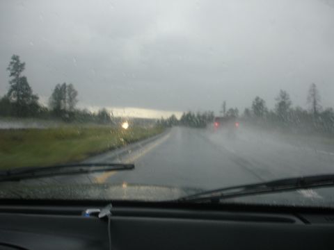 1990 Ford Taurus - Driving on a wet highway during a rainstorm, with limited visibility and other cars ahead.