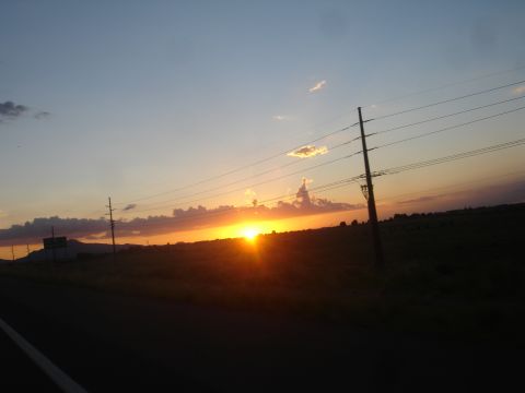 1990 Ford Taurus - A scenic sunset over a vast, open landscape, with power lines stretching across the horizon.