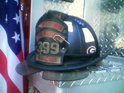 1992 Ford F-150 - Black leather firefighter helmet with a front shield reading "399" and a name plate "K. STOKES" above a fire rescue banner, sitting on a di…