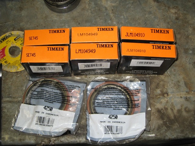 Boxes of Timken bearings and seals and two sealed packages of wheel seals on a concrete surface.