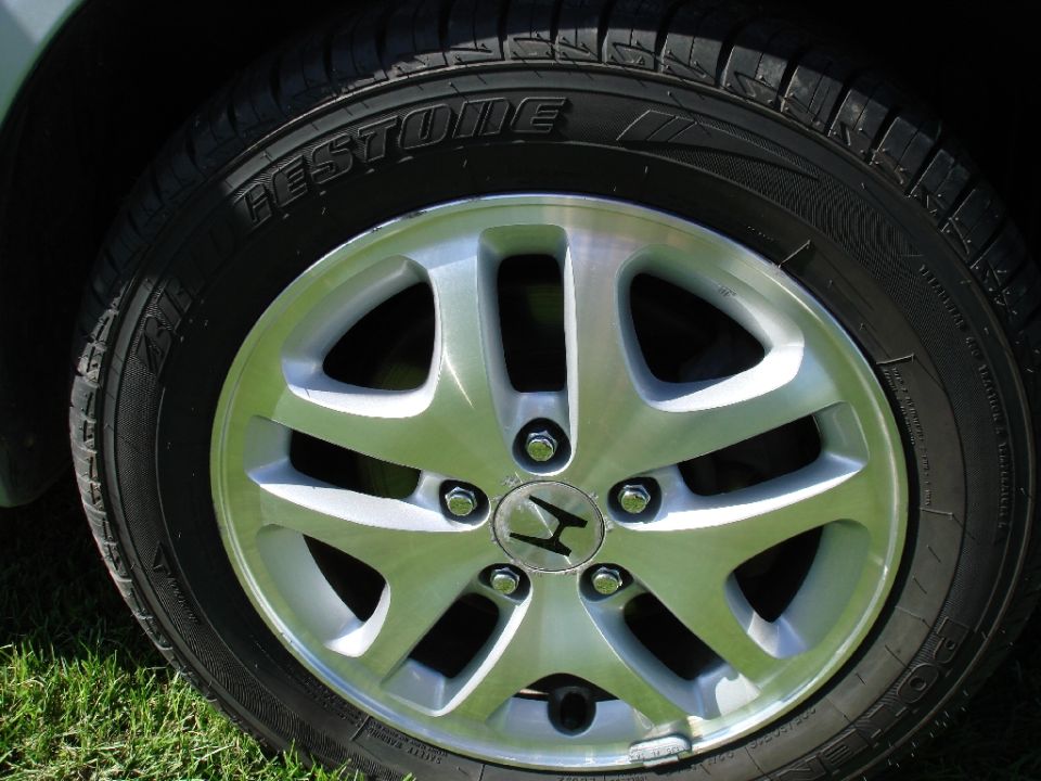 Close-up of a Bridgestone tire on a silver Honda alloy wheel.
