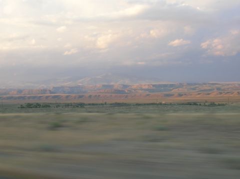 1996 Ford Bronco - A vast, open landscape stretches out under a dramatic sky, with distant mesas and blurred foreground.