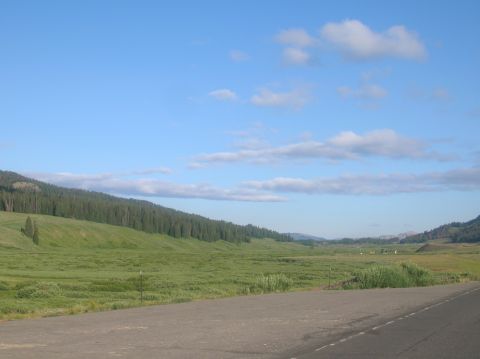 1996 Ford Bronco - A vast, open landscape unfolds with rolling green hills and a clear blue sky above.