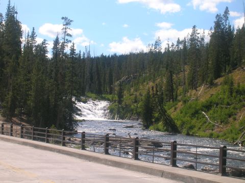 1996 Ford Bronco - A scenic view of a waterfall and river in a wooded area, with a bridge railing in the foreground.
