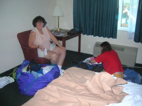 1996 Ford Bronco - Two women are in a hotel room, surrounded by luggage and clothes, preparing for a trip.