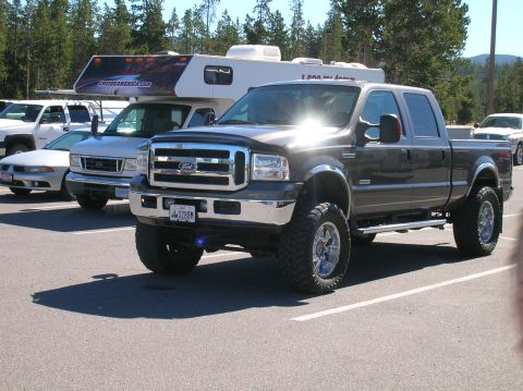 1996 Ford Bronco - This lifted Ford F-250 Super Duty pickup truck is parked in a lot with other vehicles and a camper.