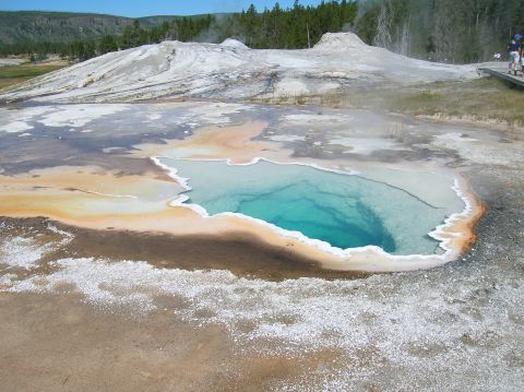 1996 Ford Bronco - A vibrant turquoise pool sits amidst mineral deposits, with a geyser steaming in the background.