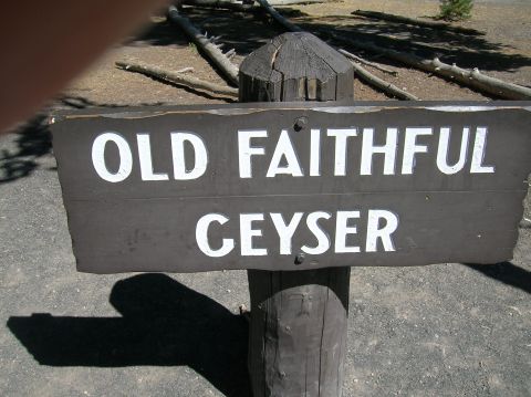 1996 Ford Bronco - A wooden sign points the way to Old Faithful Geyser, a famous landmark.