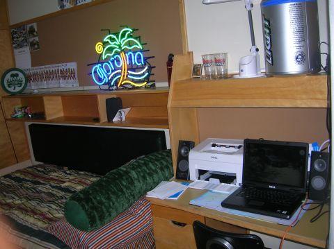 1996 Ford Bronco - A dorm room scene with a bed, desk, computer, printer, and neon sign.