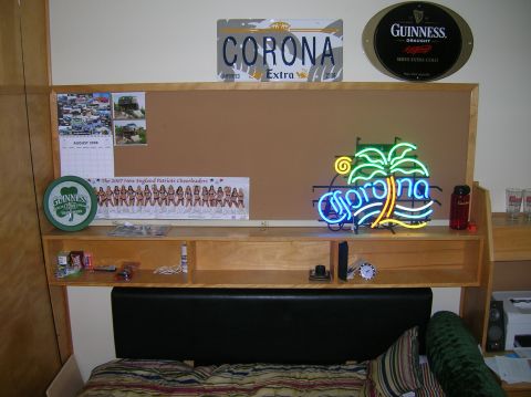 1996 Ford Bronco - A corkboard wall display features a Corona beer neon sign, license plates, a calendar, and a poster of cheerleaders.