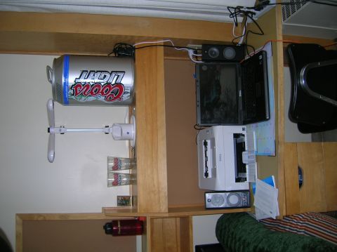 1996 Ford Bronco - A Coors Light can is mounted to a fan which is attached to a wooden shelf. Below the can are three glasses and a small framed picture. A re…