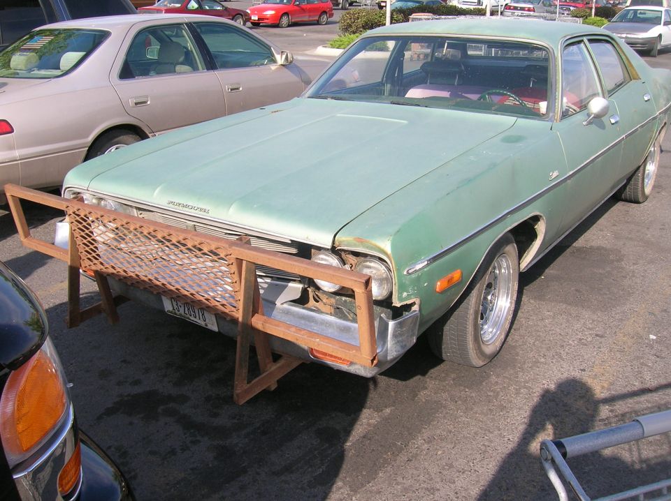 Light green sedan with a custom metal grille guard and chrome wheels.