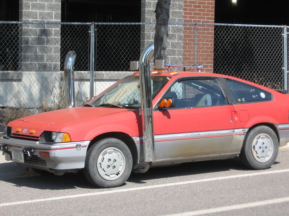 Red coupe with chrome stacks, silver trim, and license plate AC-97778.
