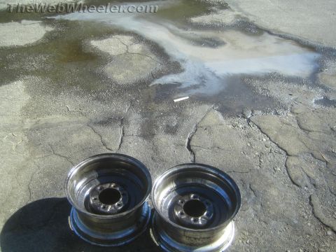 1987 Suzuki Samurai - Photograph of two steel wheel rims on the ground, not a technical document.