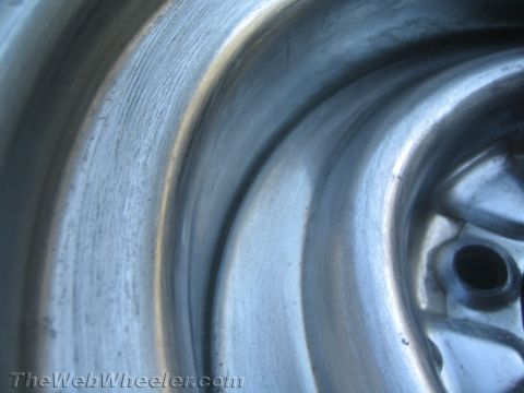 1987 Suzuki Samurai - Macro photograph of a steel wheel rim surface, not a technical document.