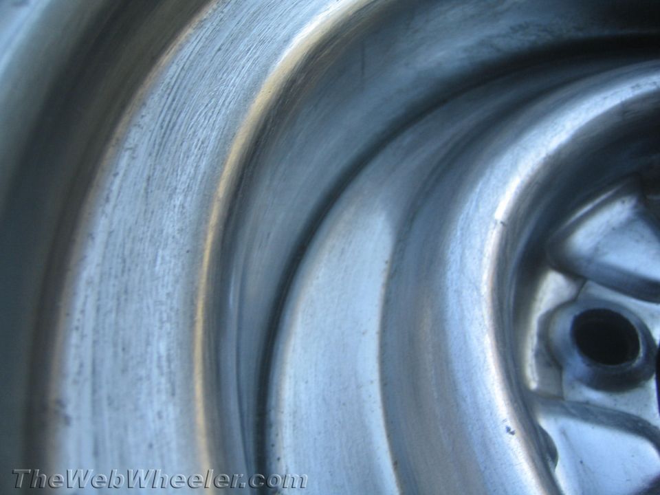 Extreme close-up of a polished steel wheel barrel and center
