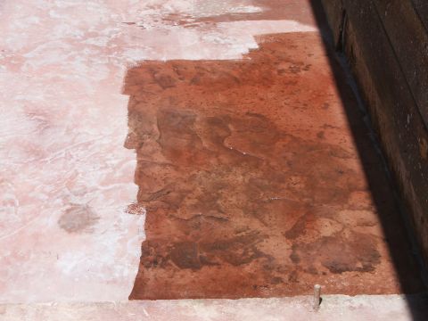 2005 Ford Mustang - A close-up view of a salt flat with areas of pinkish-white salt and reddish-brown water. A wooden structure is visible on the right side of…