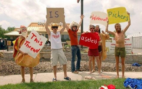 1992 Ford Mustang - A group of people are gathered outdoors, holding up various signs.