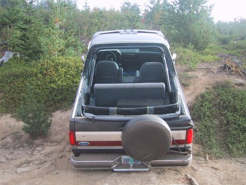 1989 Ford Bronco - This 1987 Ford Bronco convertible is seen from the rear, parked outdoors with a spare tire on the tailgate.