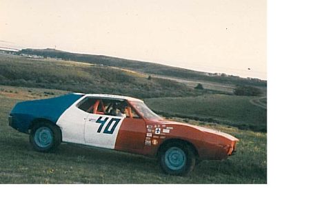 1991 Ford Bronco - A race car with the number 40 painted on the side is parked on a grassy hill with a body painted in red, white, and blue.