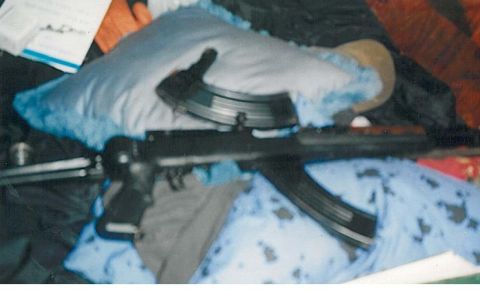 1991 Ford Bronco - A firearm with a magazine is resting on blue fabric and other items. The firearm appears to be a rifle or carbine.