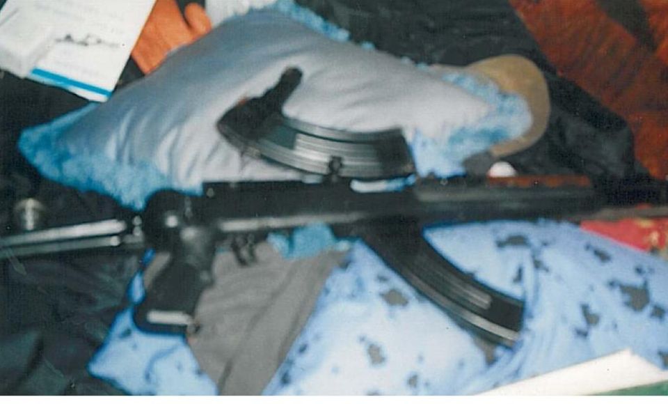 A firearm with a magazine on blue fabric.