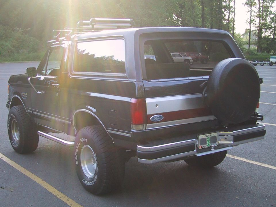 1989 Ford Bronco with spare tire on rear door, parked in lot