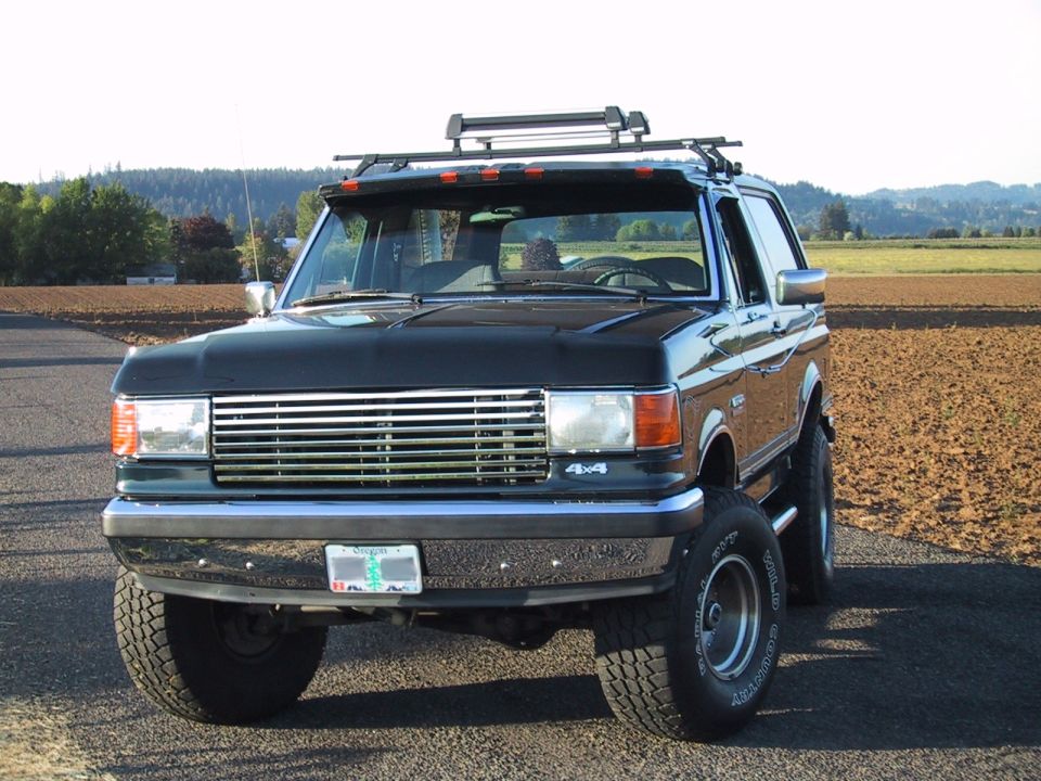 Black Ford Bronco with roof rack, lifted suspension, and aftermarket wheels
