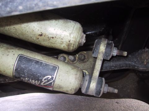 1989 Ford Bronco - Close-up view of rear shock absorbers and sway bar link, with some text visible on the shock absorber.
