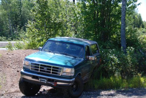 1996 Ford Bronco - Photograph of a teal Ford Bronco on a dirt embankment, not a technical document.