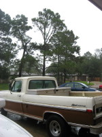 1972 Ford F-100 - The side view of a two-tone brown and white 1970s Ford F-series pickup truck is shown parked outdoors on a cloudy day. A silver toolbox is…
