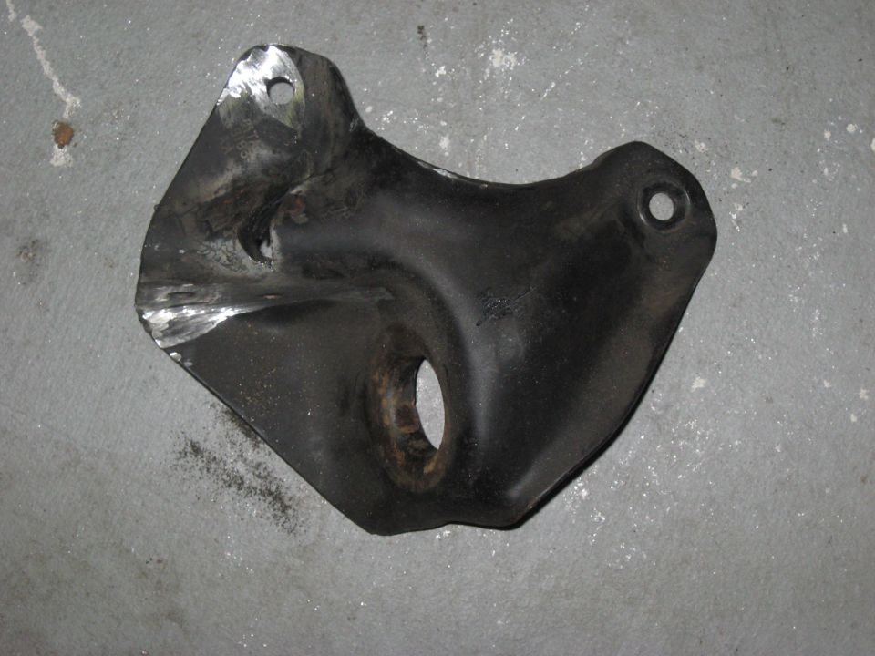 Black metal bracket with mounting holes on a concrete floor