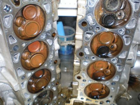 2007 Ford Mustang - Photograph of installed cylinder heads showing combustion chambers and carbon deposits, not a technical document.