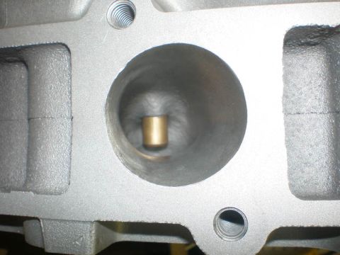 2007 Ford Mustang - Photograph of an intake port and guide on an aluminum cylinder head, not a technical document.