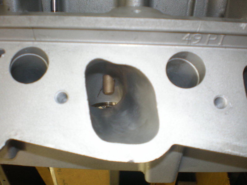 Close-up photo of a cylinder head intake port marked 49 PI