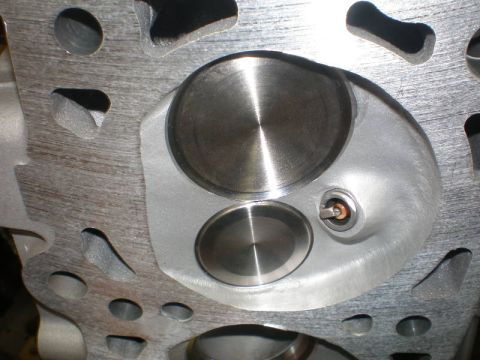 2007 Ford Mustang - Photograph of a cylinder head combustion chamber with machined valve seats, not a technical document.