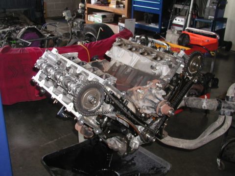2007 Ford Mustang - Photograph of an overhead-cam V engine with exposed timing chains during assembly, not a technical document.