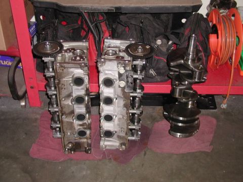2007 Ford Mustang - Photograph of two cylinder heads and a crankshaft on a shop bench, not a technical document.